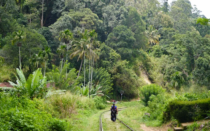 Mujer caminando sobre las vías del tren de Ella