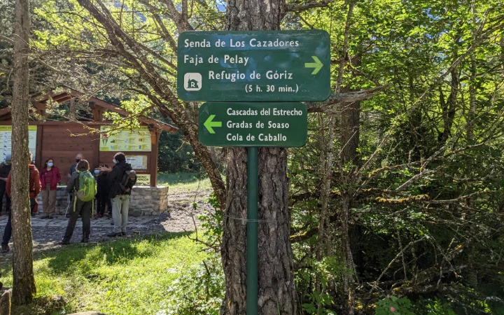 Carteles indicativos de la Senda de Los Cazadores en la pradera